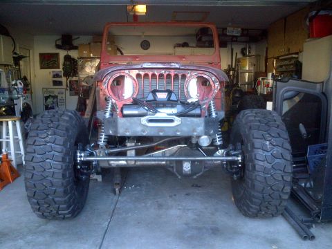 1985 Jeep CJ7 - Front view of a 1985 Jeep CJ7 undergoing modifications in a garage.