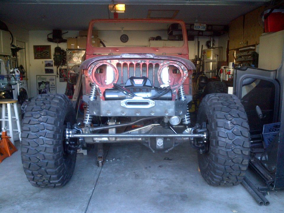 1985 Jeep CJ7 front end in garage, showing winch and large tires