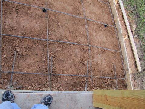 1995 Ford Bronco - A rebar grid is laid out on dirt within wooden forms, with the Supermotors logo visible in the lower right corner.