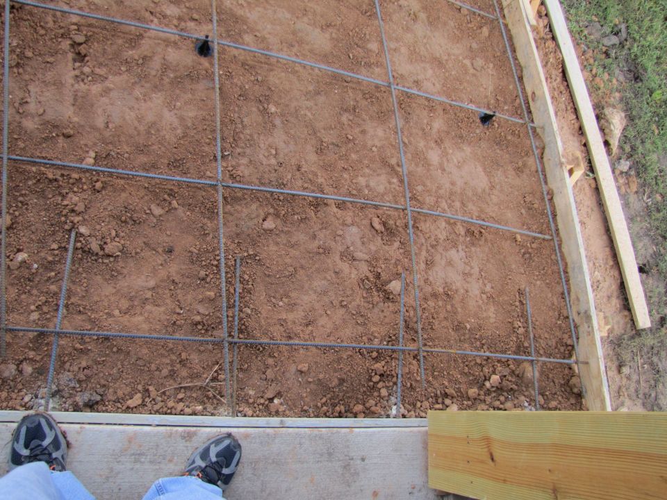 Rebar grid on dirt with wooden forms and Supermotors logo