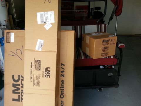 1994 Ford Bronco - Several boxes are stacked and placed on a golf cart, with a toolbox visible in the background.