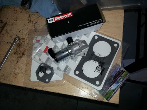 1994 Ford Bronco - Motorcraft idle air control valve and gaskets laid out on a wooden surface.