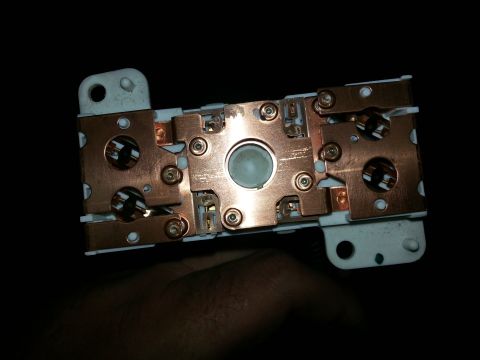 1994 Ford Bronco - This electrical component features copper contacts and a white housing, likely part of a vehicle's wiring system.