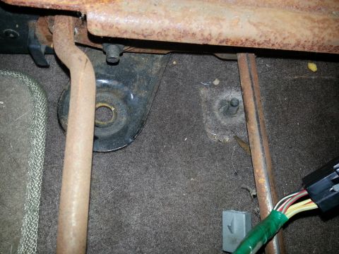 1994 Ford Bronco - Detail of seat mounting hardware and wiring harness, likely from a vehicle interior. The registry's claim of a 1994 Ford Bronco is not supp…