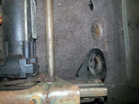 1994 Ford Bronco - Detail of a car seat's mounting bracket and electric motor, showing carpeted interior.