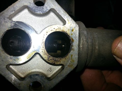 1994 Ford Bronco - Close-up of a throttle body, showing internal wear and a numerical marking.