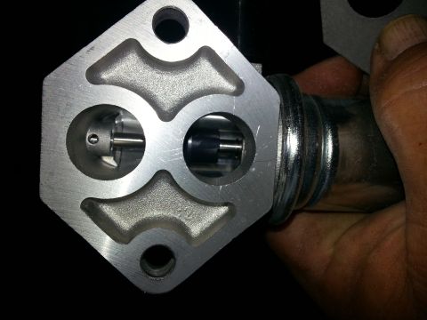 1994 Ford Bronco - A throttle body part is shown in detail, highlighting its internal components and metallic construction.