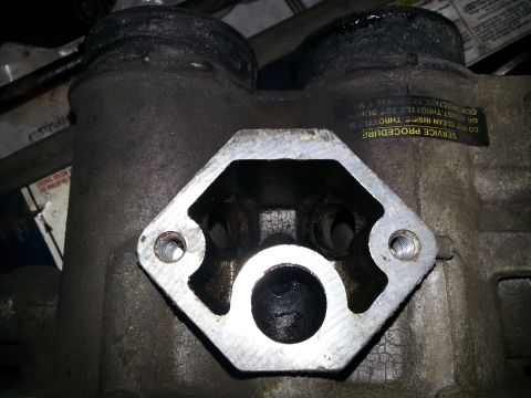1994 Ford Bronco - Close-up of a dirty throttle body, showing internal components and mounting points.