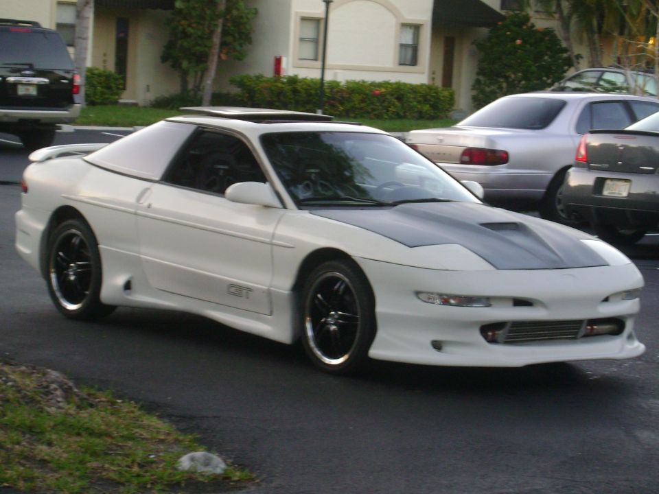 White Ford Probe with a grey hood and black rims parked on asphalt