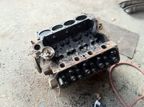 1978 Ford Bronco - Engine block with internal components exposed, sitting on a rough ground surface.