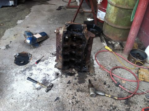 1978 Ford Bronco - Disassembled engine block and associated parts scattered on a workshop floor.