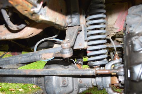 1989 Ford Bronco - Undercarriage view of a vehicle's suspension system with visible rust and wear.