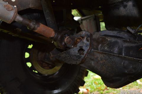 1989 Ford Bronco - Underside view of a vehicle's drivetrain components, including the driveshaft and rear differential, with a tire in frame.