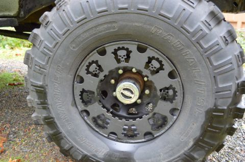 1989 Ford Bronco - A close-up view of a tire and a custom wheel with skull designs, showing no definitive year identification.