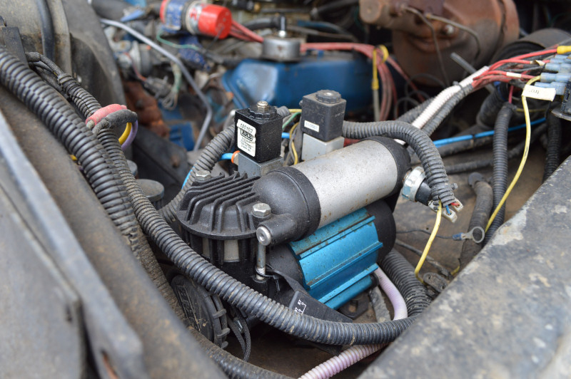Engine bay with an air compressor and lots of wiring