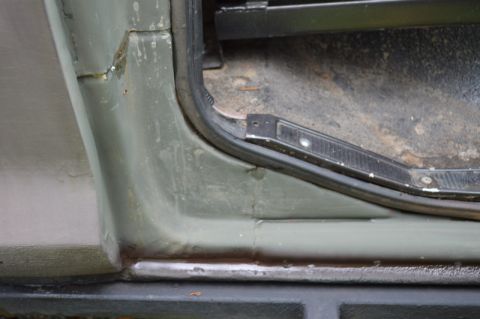 1989 Ford Bronco - Detail of the door jamb and floor area of an older vehicle, showing signs of use.