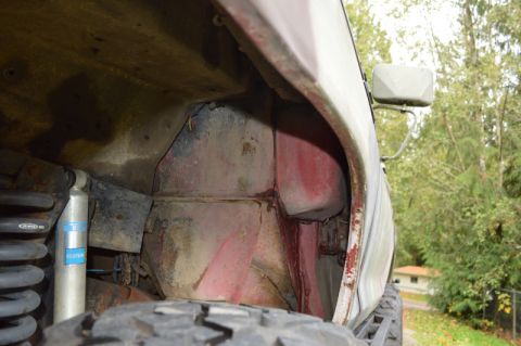 1989 Ford Bronco - Detail shot of the wheel well area, revealing suspension components and signs of wear.