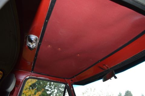 1989 Ford Bronco - Interior view of a red vehicle's headliner and trim, showing a dome light.