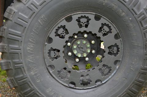 1989 Ford Bronco - This custom wheel has a unique design with skull and gear patterns cut into the metal.