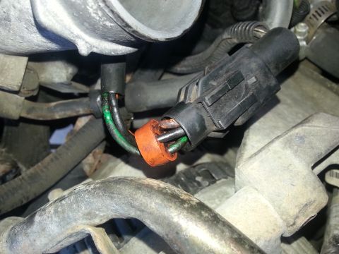 1994 Ford Bronco - Close-up view of a throttle body sensor connector showing exposed wires and an orange seal.