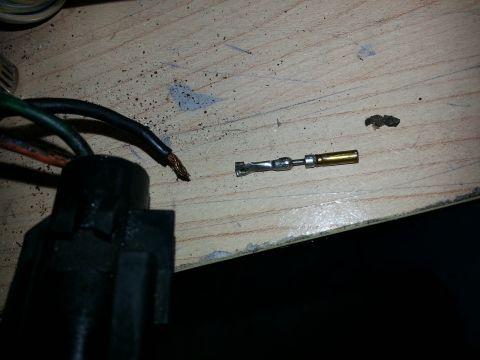 1994 Ford Bronco - An automotive electrical connector and a loose terminal are shown on a workbench.