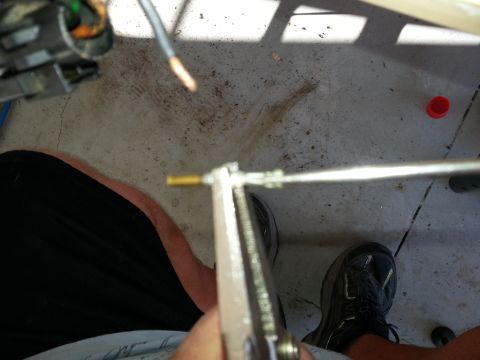 1994 Ford Bronco - A close-up view of a throttle body part with wires and a metal rod being manipulated.