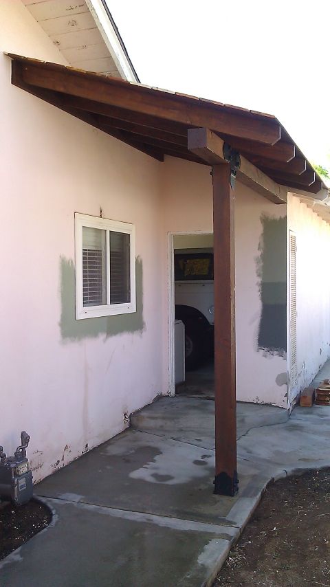 1996 Ford Bronco - A view of a house's exterior, showing a covered entryway and a glimpse of a vehicle inside.