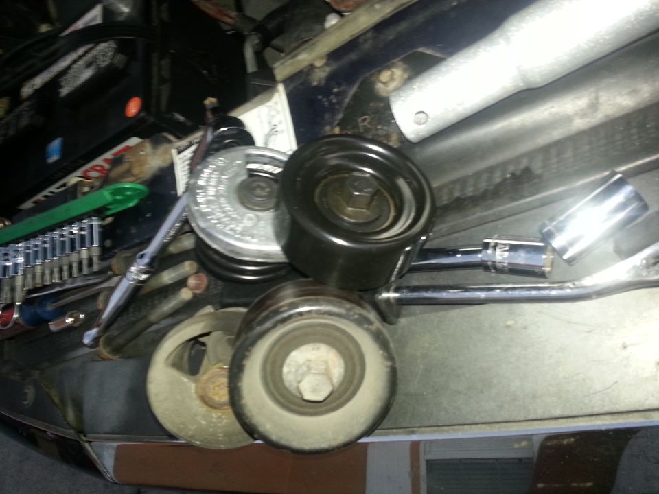 Alternator pulley and tensioner assembly with socket wrench and other tools