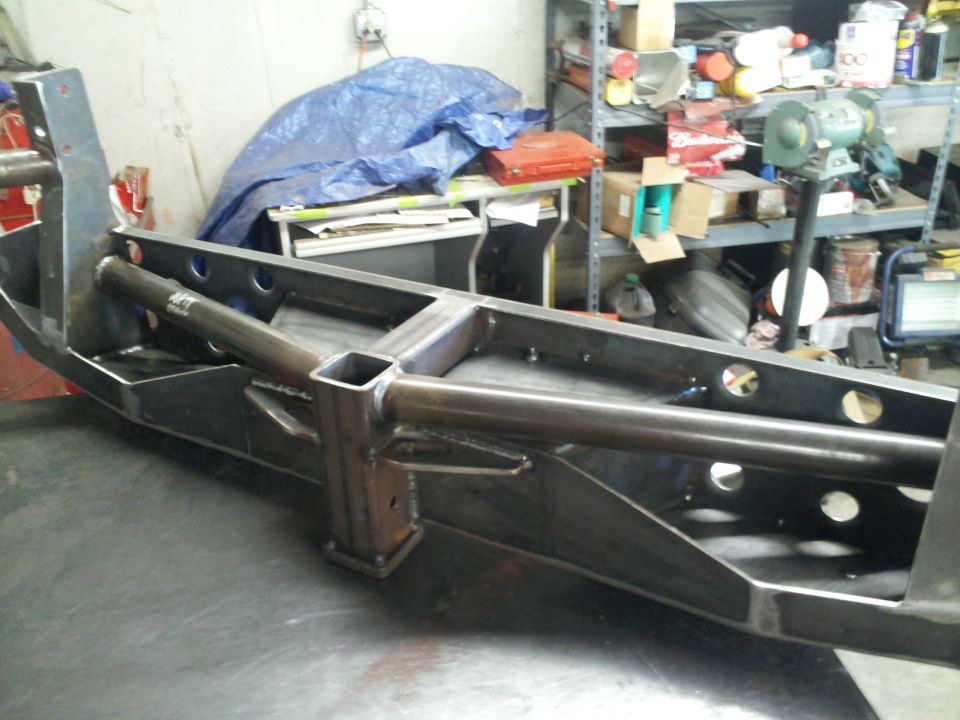 Custom metal frame with tubular supports and square mounting points, viewed from a 3/4 front angle