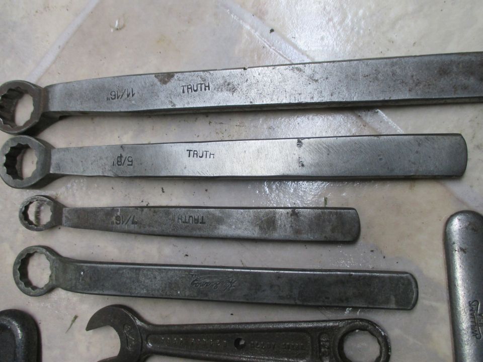 Several metal wrenches with sizes like 11/16, 5/8, and 7/16 marked on them