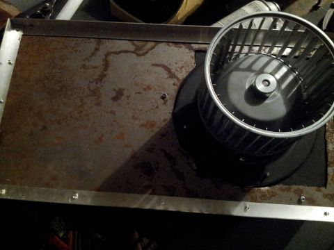 1973 Ford Ranchero - A blower motor sits on a corroded metal surface, suggesting a component from a vehicle or machinery.
