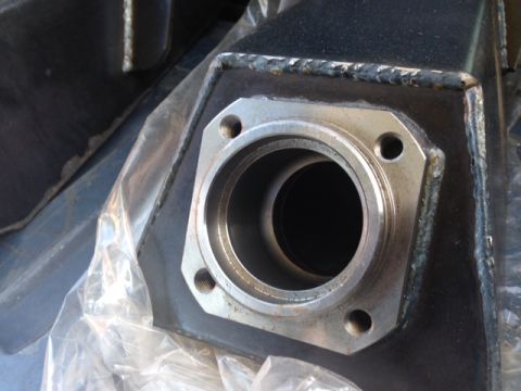 1986 Ford Bronco - This image shows a close-up view of a metal component, possibly a suspension part, with a flanged opening and bolt holes. The part is parti…
