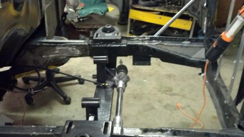 1964 Ford Fairlane - The chassis of a vehicle is visible, undergoing repairs or modifications in a workshop setting.