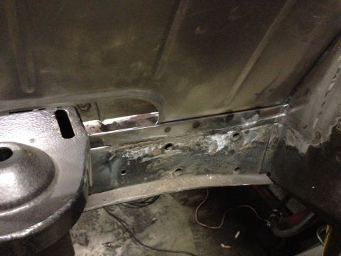 1964 Ford Fairlane - The underside of a vehicle shows metal repair work on the frame, indicating restoration or maintenance.