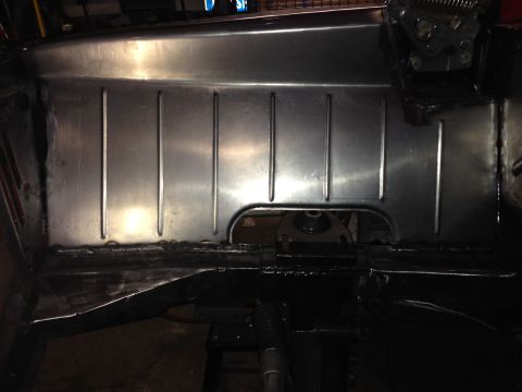 1964 Ford Fairlane - Close-up view of a metal floor pan, showing its ribbed texture and a cut-out section.