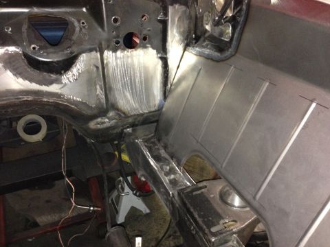 1964 Ford Fairlane - Metal fabrication work on a car's chassis, showing welded seams and new panel installation.