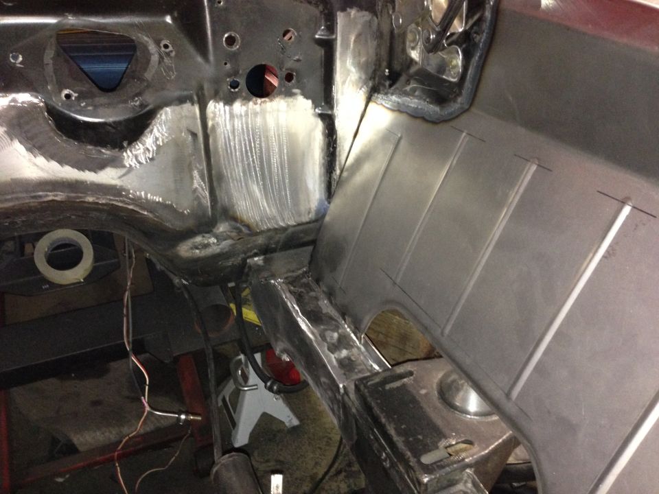 Car frame undergoing repair with new metal panels welded in place
