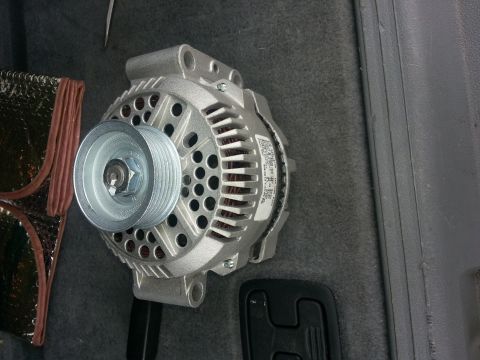 1994 Ford Bronco - An alternator is shown in a vehicle's interior, likely for replacement or repair.