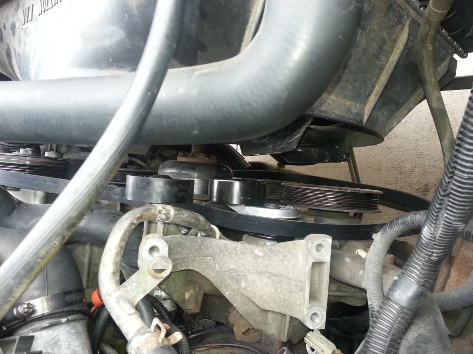 Engine belt tensioner and pulleys with hoses and belts