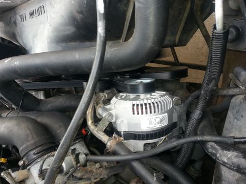 1994 Ford Bronco - Close-up view of a vehicle's alternator and associated engine components.