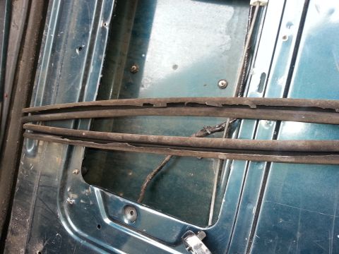 1994 Ford Bronco - Worn rubber seals are visible on the interior of a teal-colored vehicle panel.
