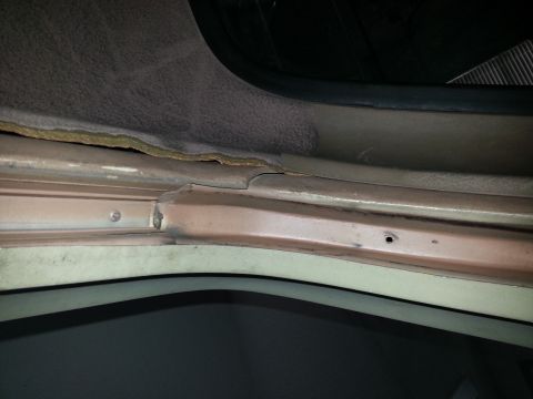 1994 Ford Bronco - Close-up of the interior trim of a vehicle, revealing a gap and exposed metalwork.