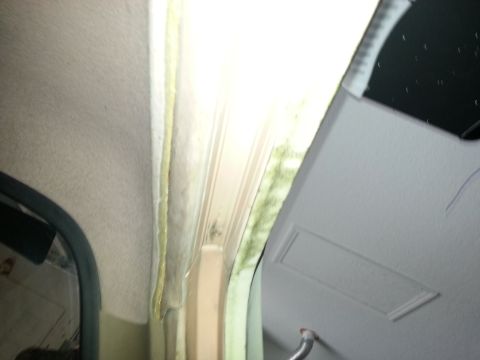 1994 Ford Bronco - Close-up of interior trim and insulation, showing exposed materials and a reflection.