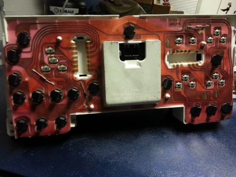 1994 Ford Bronco - The back of a vehicle's instrument cluster circuit board is visible, showing its intricate wiring and connectors.