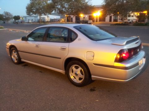 2001 Chevrolet Impala - Silver sedan parked on asphalt, showing its rear quarter panel and taillights.