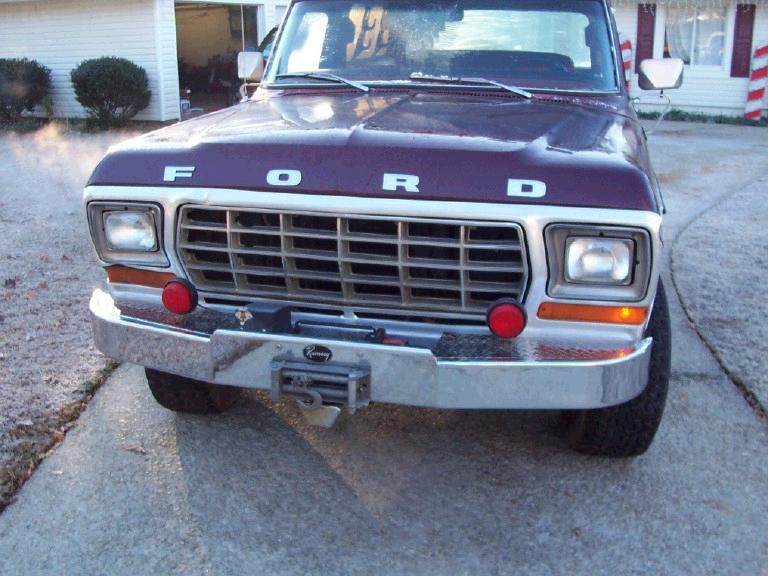 Front of dark maroon 1979 Ford with FORD hood letters, chrome grille, and Ramsey winch on front bumper