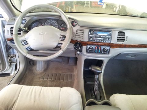 2001 Chevrolet Impala - The interior of a car, the steering wheel, dashboard, and center console with radio and climate controls.