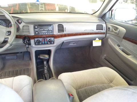 2001 Chevrolet Impala - The interior of a car shows beige seats, a wood-trimmed dashboard, and an automatic transmission shifter.
