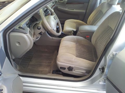 2001 Chevrolet Impala - The interior of a 2001 Chevrolet Impala features cloth seats and a beige dashboard.