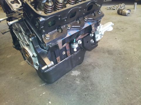2001 Chevrolet Impala - Engine block with exposed valves and oil pan sits on a concrete floor, likely awaiting installation or repair.